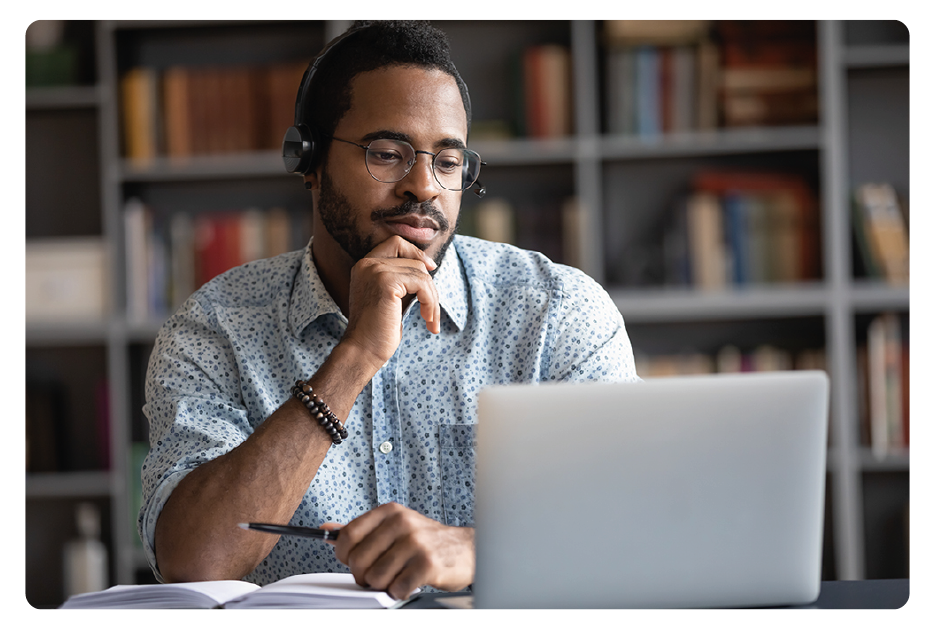 Man watching a webinar on his laptop with headphones on